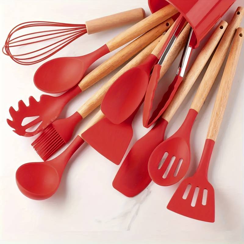 Red silicone kitchen utensil set with light wood handles: whisk, spatulas, slotted spoon
