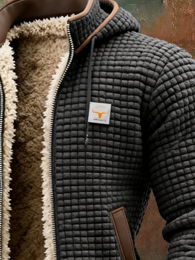 Men's black quilted sherpa-lined jacket close-up, chest logo patch and brown trim pocket