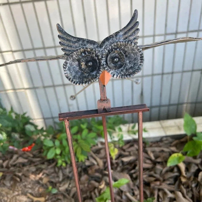 Wind-powered owl garden stake, blue-gray owl with orange beak on a metal post