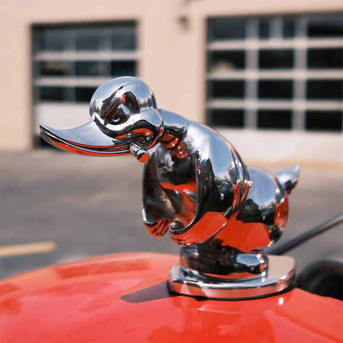 Chrome duck hood ornament with orange-red accents and glossy black details