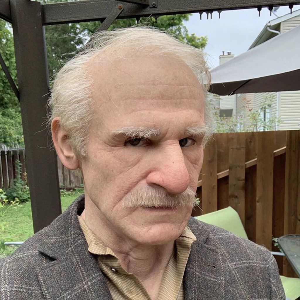 Realistic latex Halloween mask with gray hair, arched brows, and thin mustache
