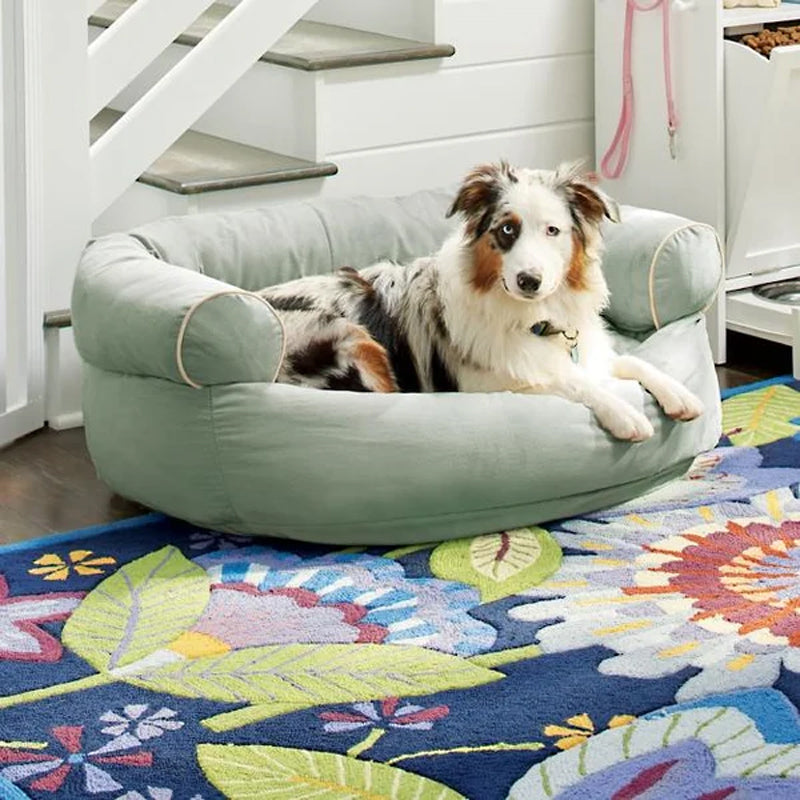 Bolster dog bed with rolled sides, light green fabric and rounded front openings