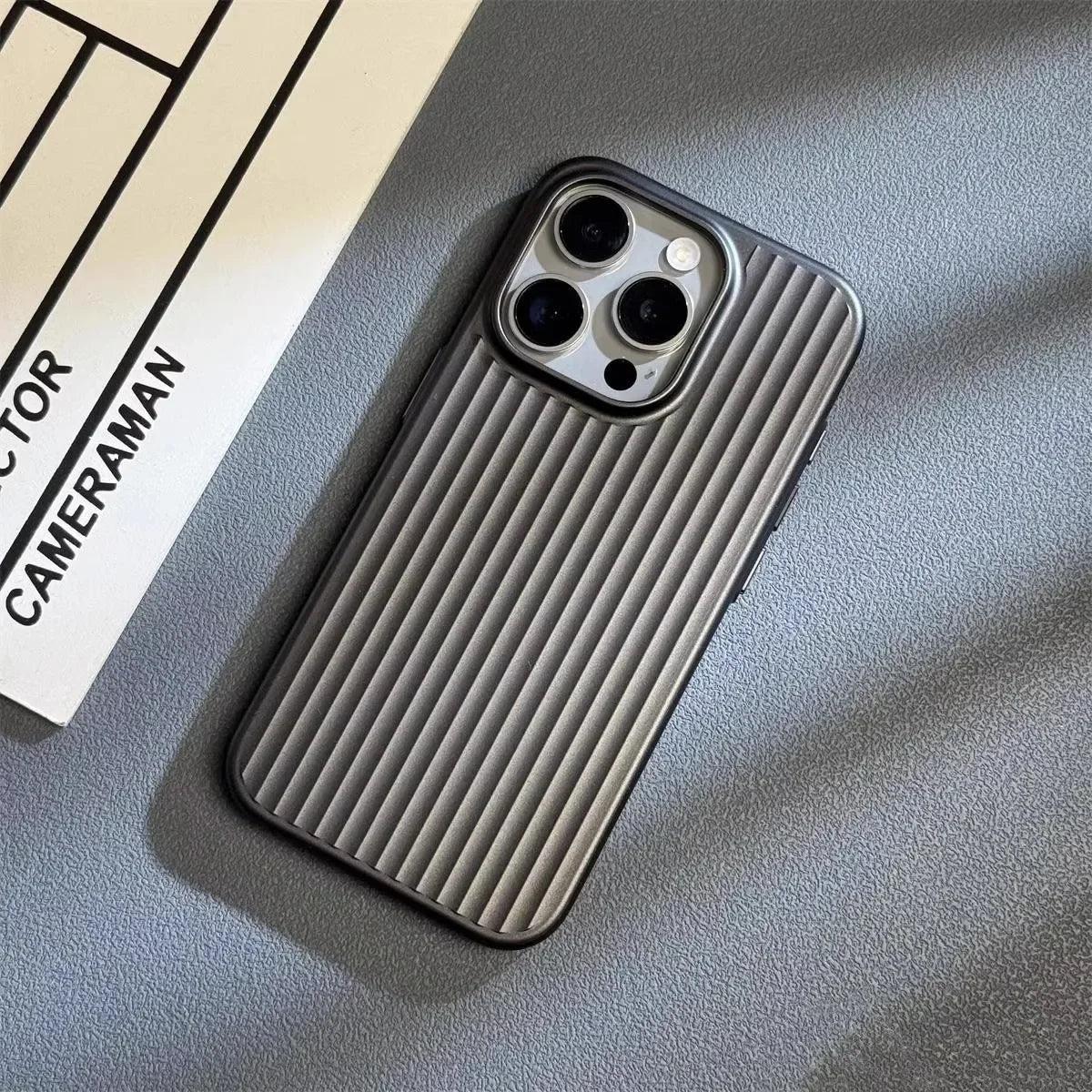 Dark gray iPhone case with vertical ridged pattern and triple camera cutouts