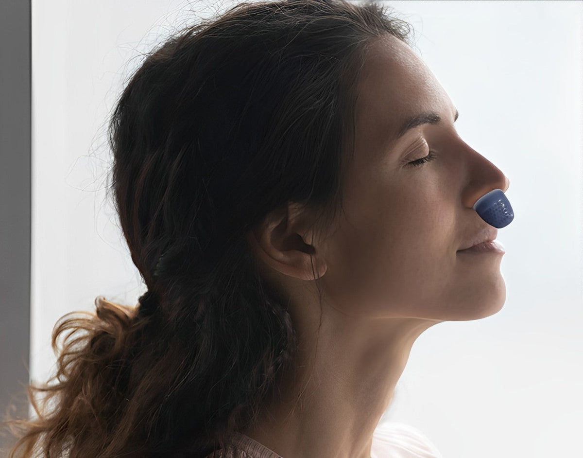 Portable anti-snoring device worn on side of nose with blue nasal tip
