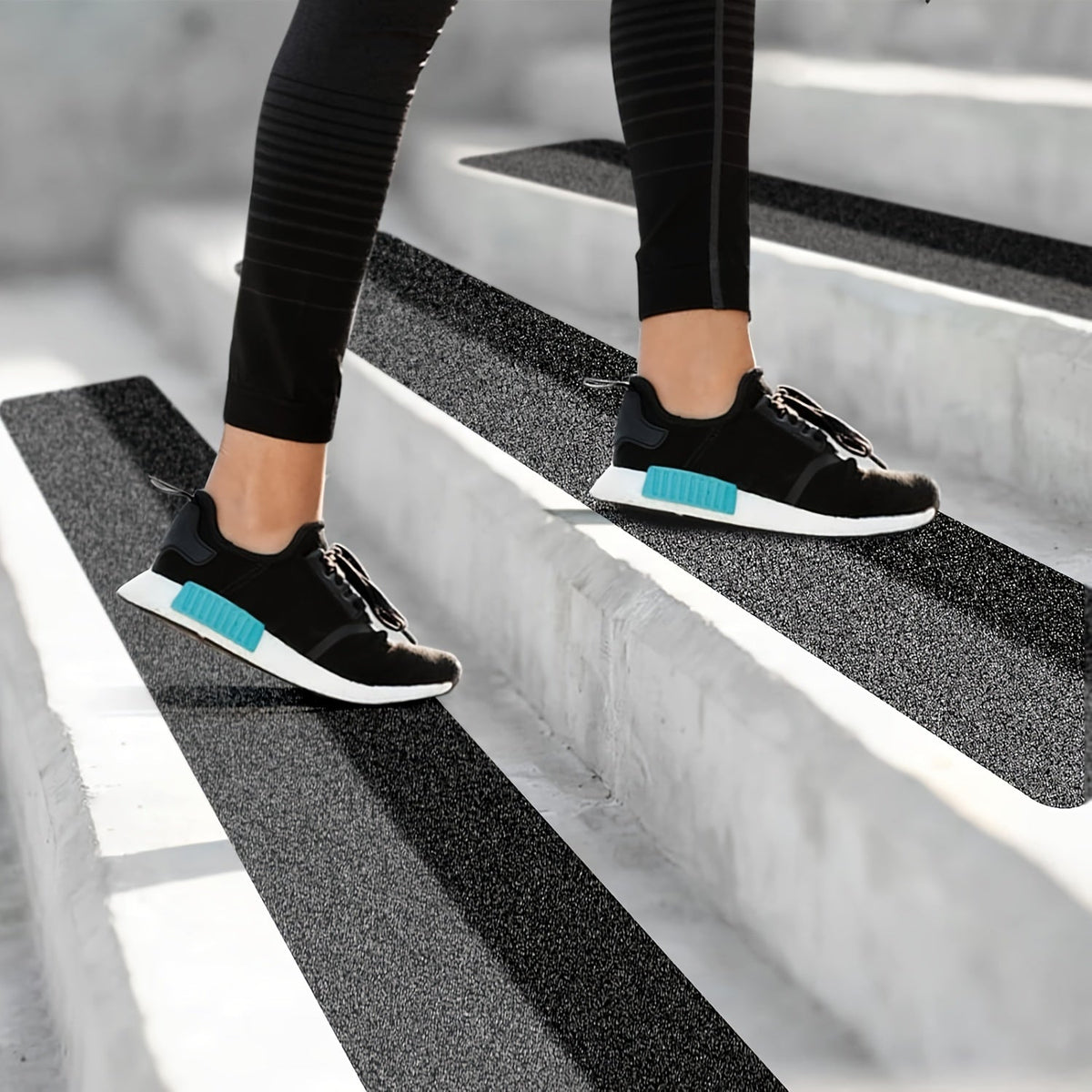 Black anti-slip stair tread strips under sneakers for improved grip