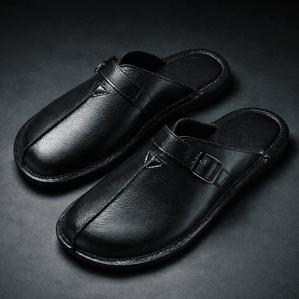 Black buckle-strap backless loafers with metal buckle detail and stitched center panel