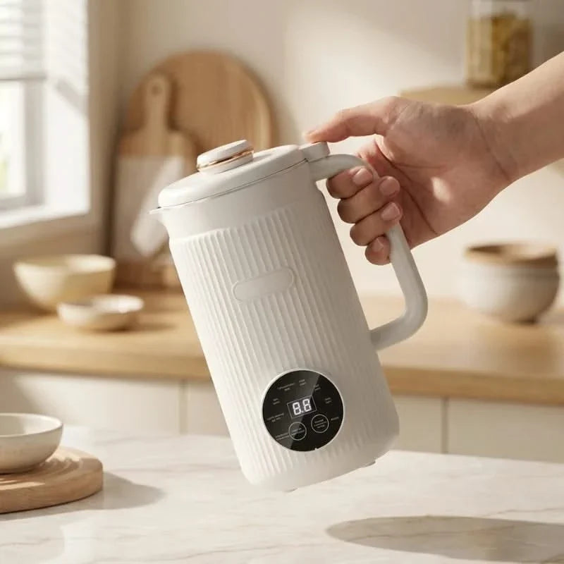 White blender pitcher held by hand, showing front digital mode display