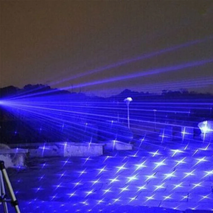 Blue laser grid pattern from handheld torch, with bright star-like sparks