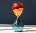 Hourglass sand timer with red-to-orange top and blue-green bottom glass