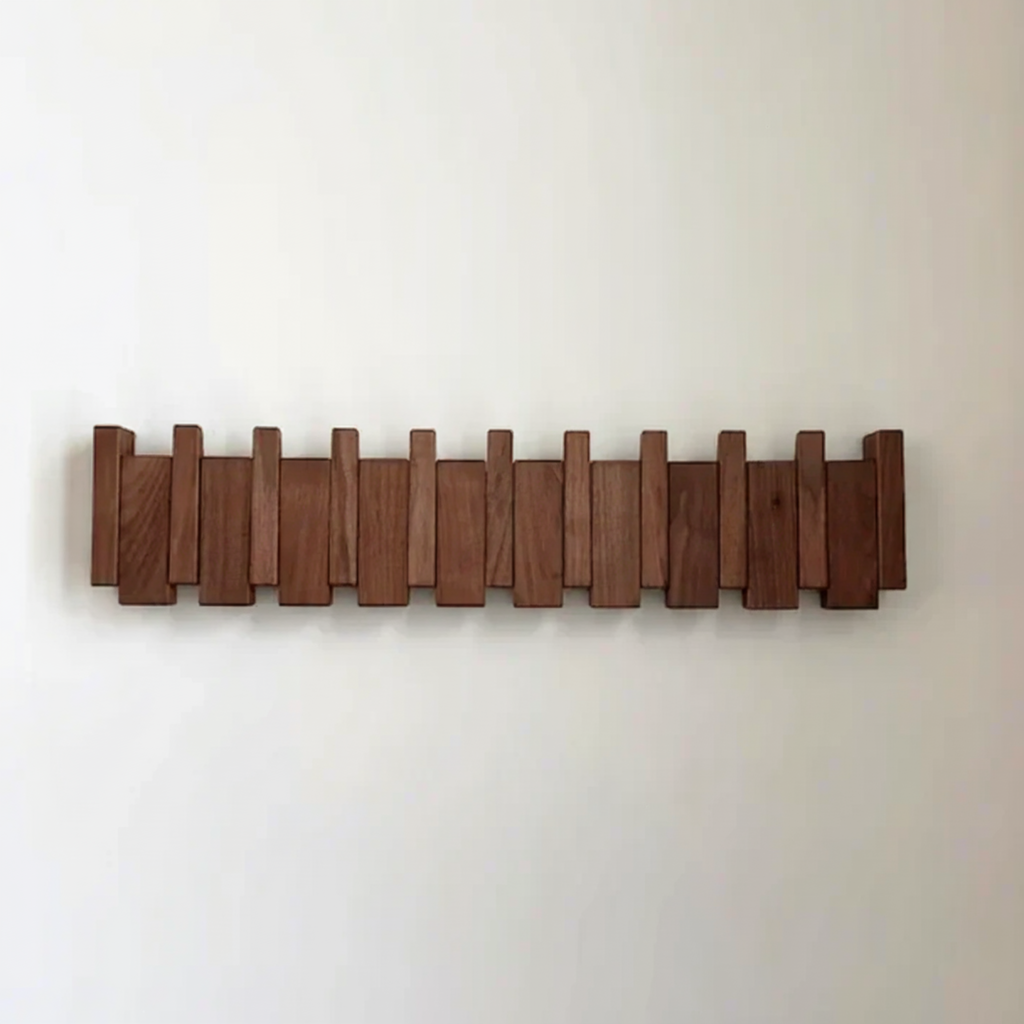 Dark wood wall coat rack with piano-style slats and angled coat hooks