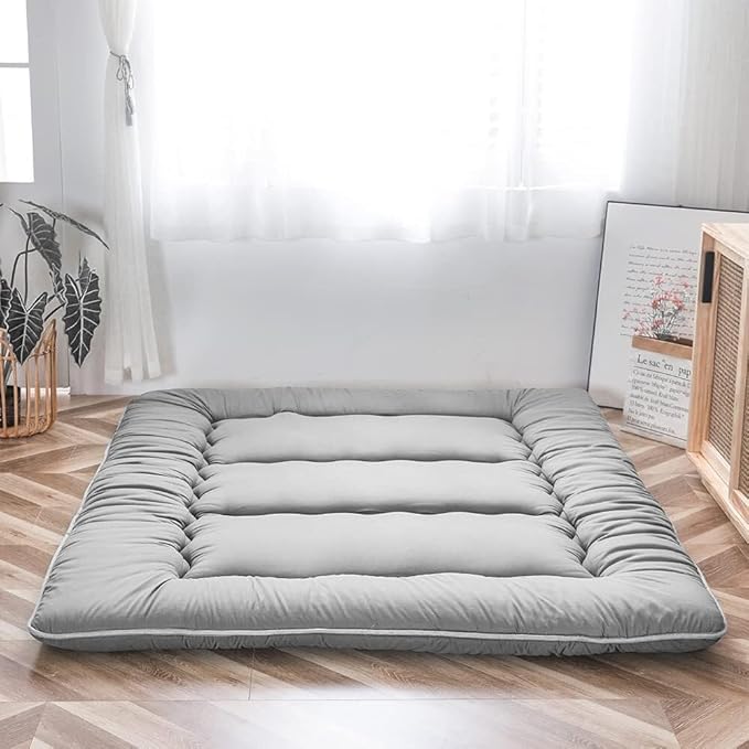 Grey foldable floor futon mattress laid flat with quilted, cushioned sections