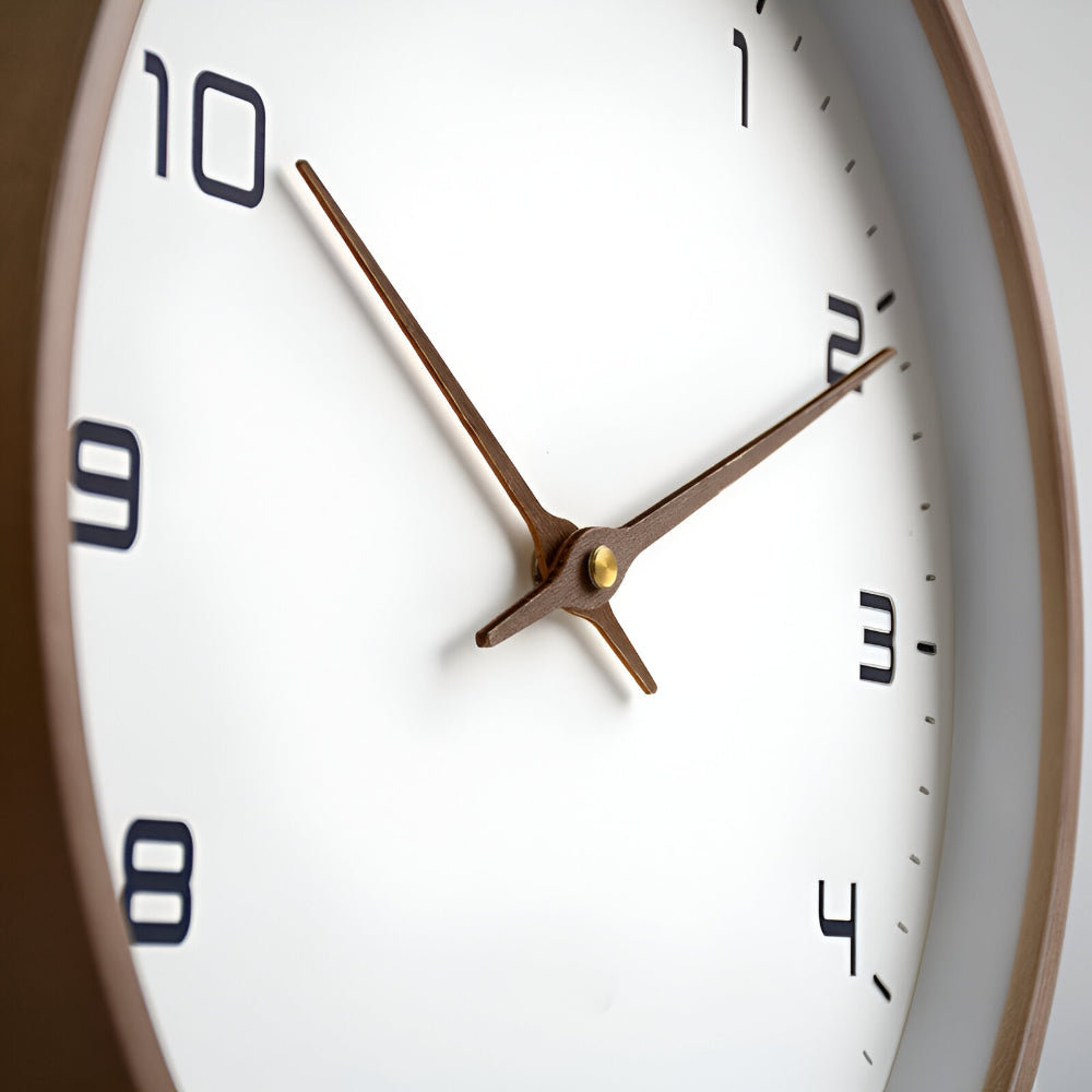 Brown rim wall clock close-up with cream face, gold hands, and black numerals