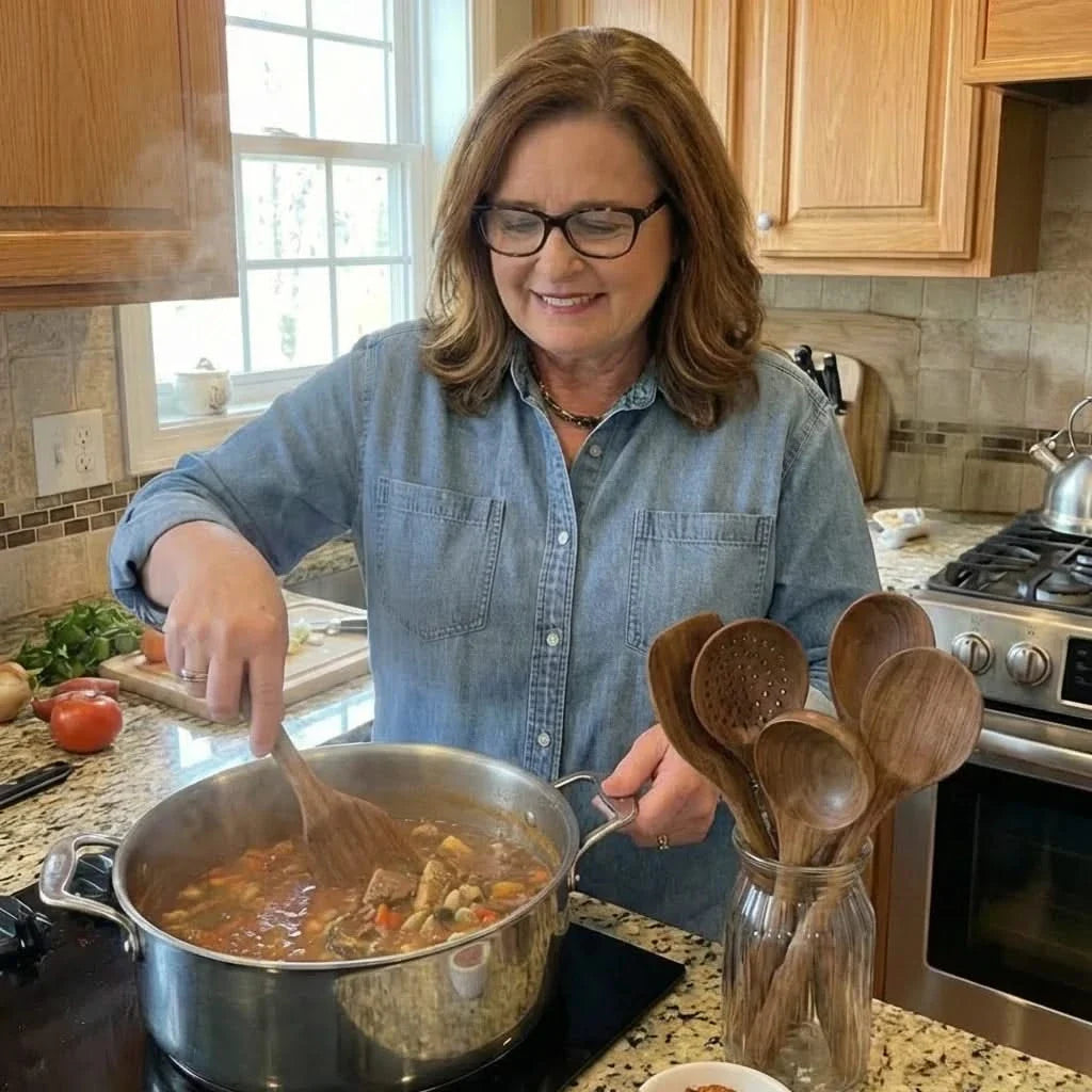 Teak wooden cooking utensils held while stirring a pot in a home kitchen