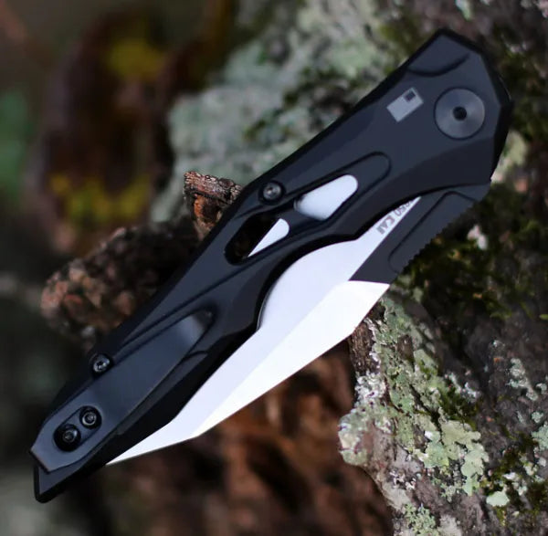 Black auto-fold utility knife with wharncliffe blade, side close-up