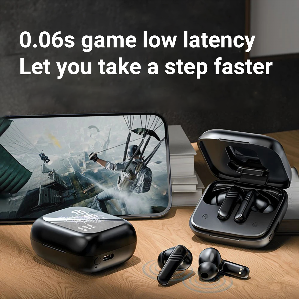 Black TWS earbuds with open charging case on a tabletop