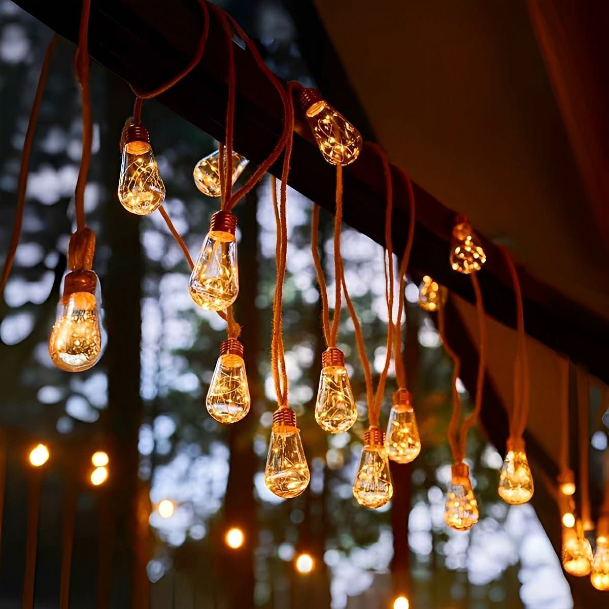 Outdoor solar string lights with vintage amber bulbs on brown hemp rope