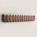 Row of dark and light wood pegs on a wall, piano-key style coat hook hanger
