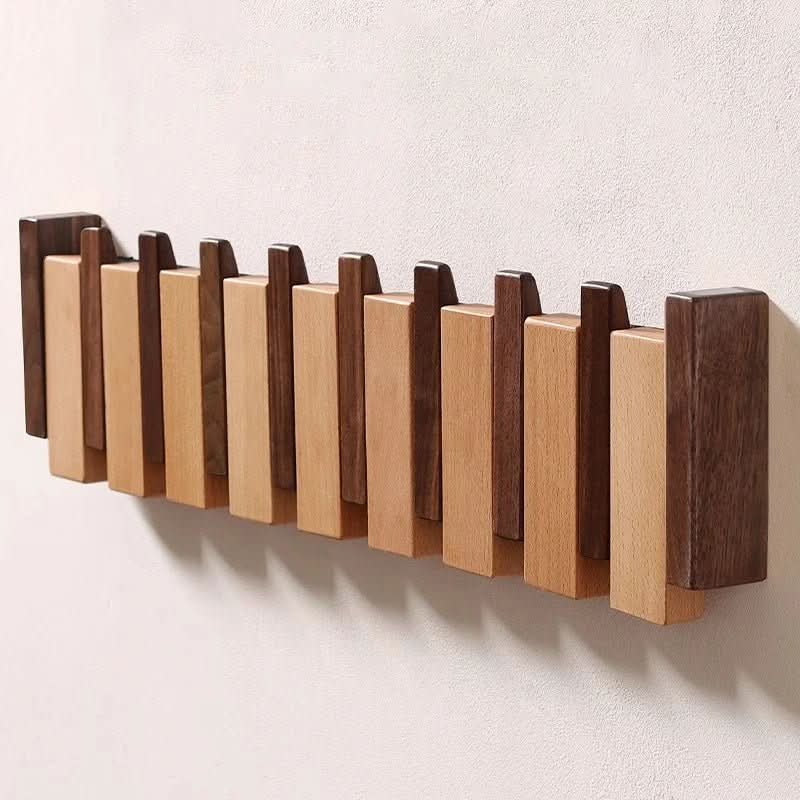 Piano-style wooden wall hanger with alternating light and dark pegs for hanging items