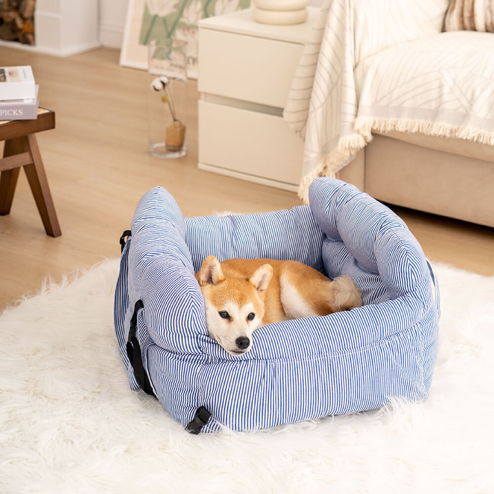 Blue striped padded dog booster bed with detachable bolsters on a soft indoor surface