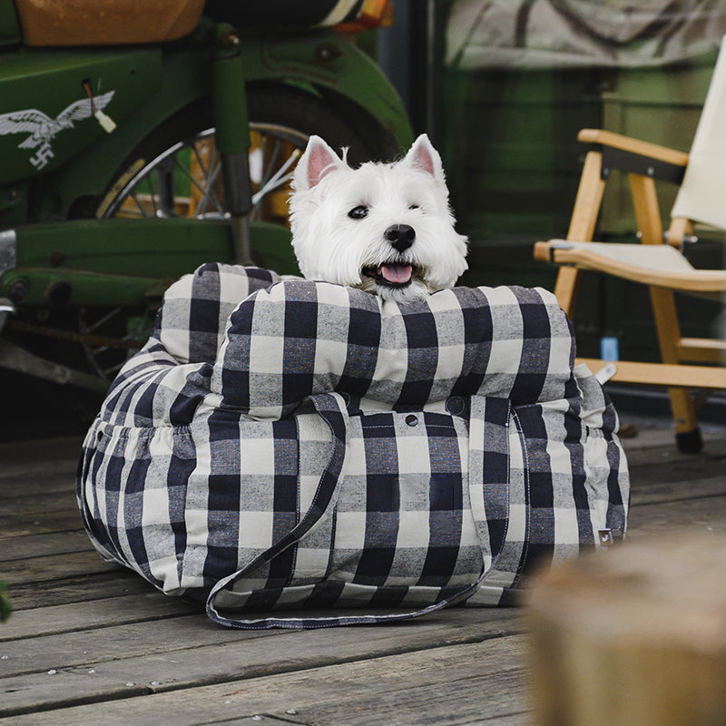 Black and white checked padded dog booster seat with overstuffed bolsters outdoors