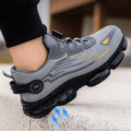 Grey steel-toe work shoe on foot, lace-up straps with rugged black outsole
