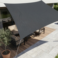 Waterproof UV shade sail in dark gray, triangular canopy stretched over patio furniture