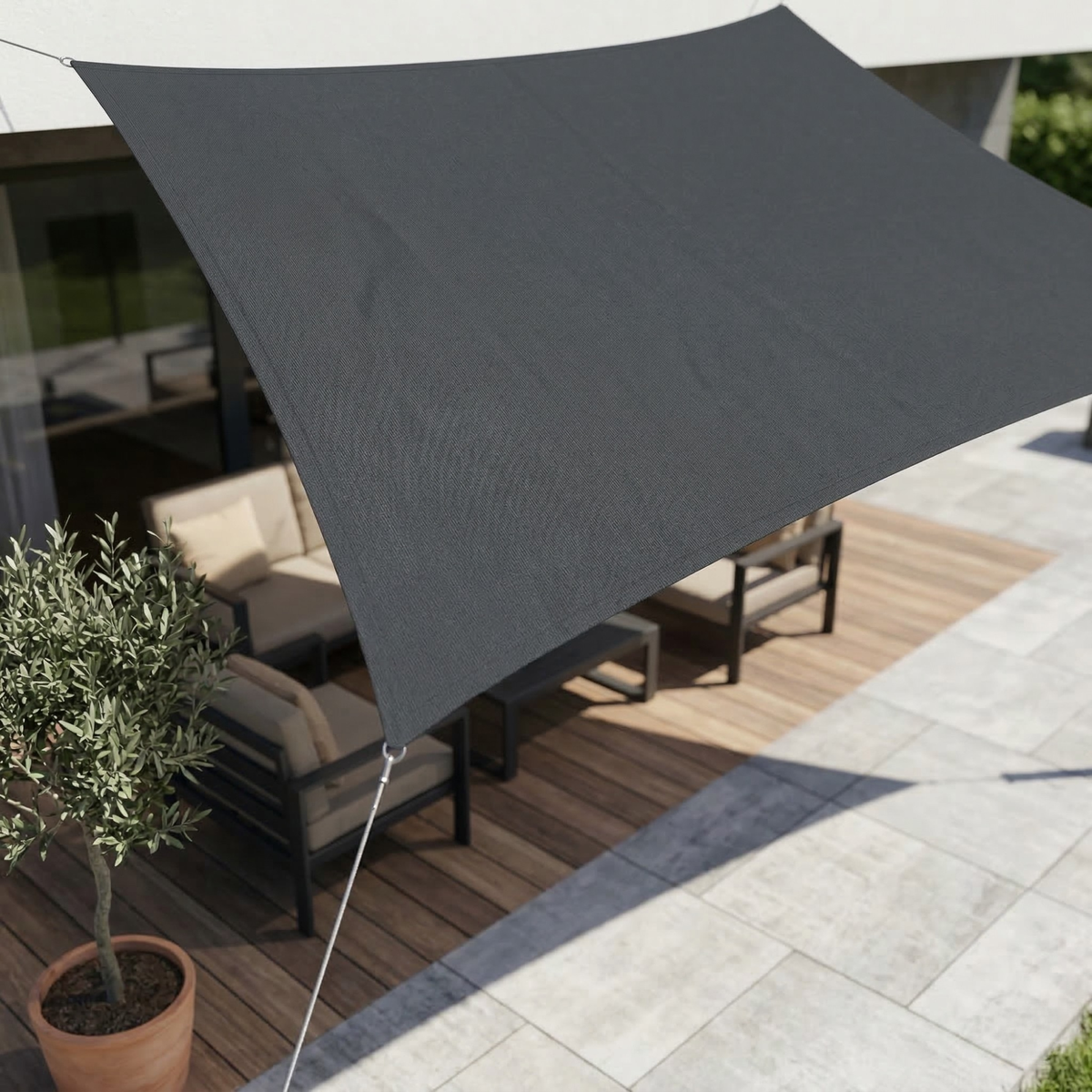 Waterproof UV shade sail in dark gray, triangular canopy stretched over patio furniture