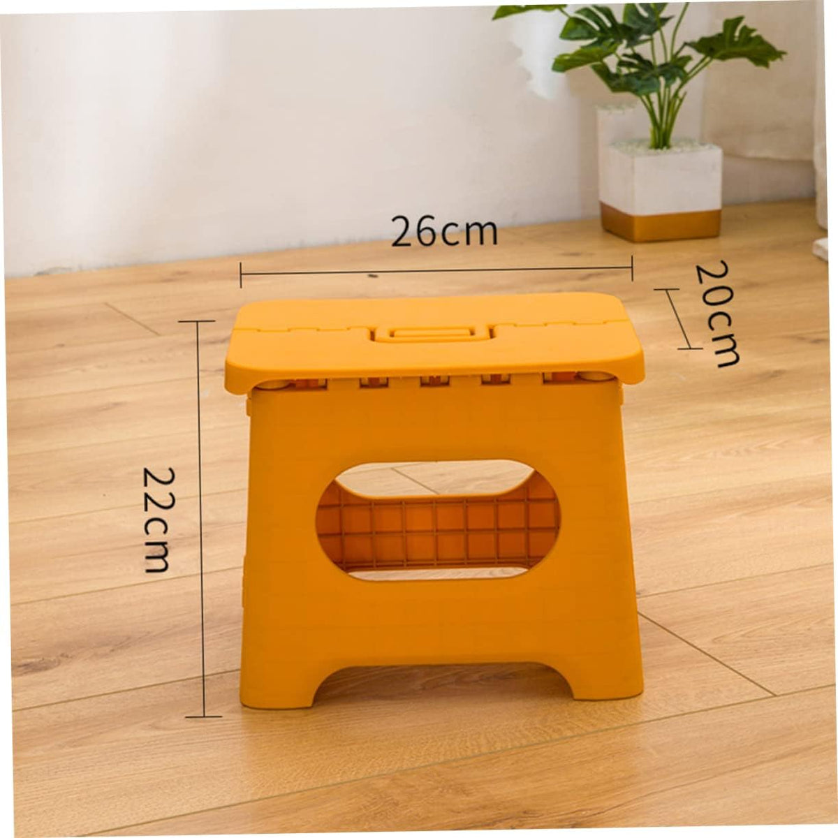 Foldable step stool in yellow with oval safety cutout and top carrying handle.