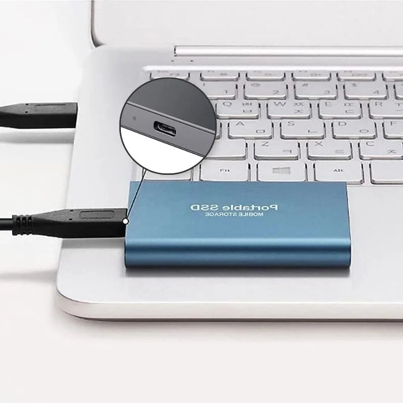 Blue portable SSD drive plugged into a laptop, shown from above