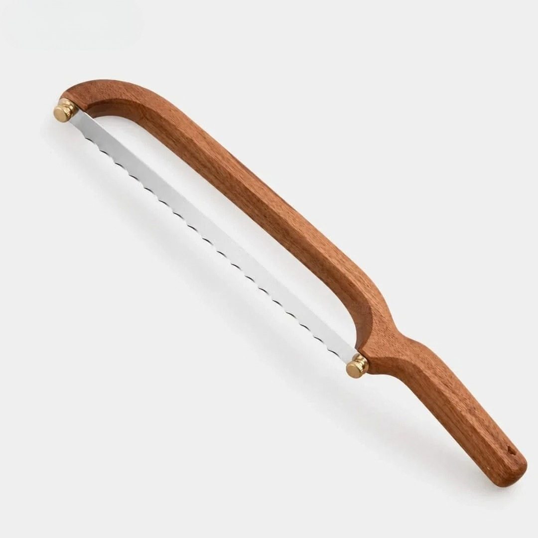 Bow-saw bread knife with serrated stainless blade, brown wooden handle and brass knobs