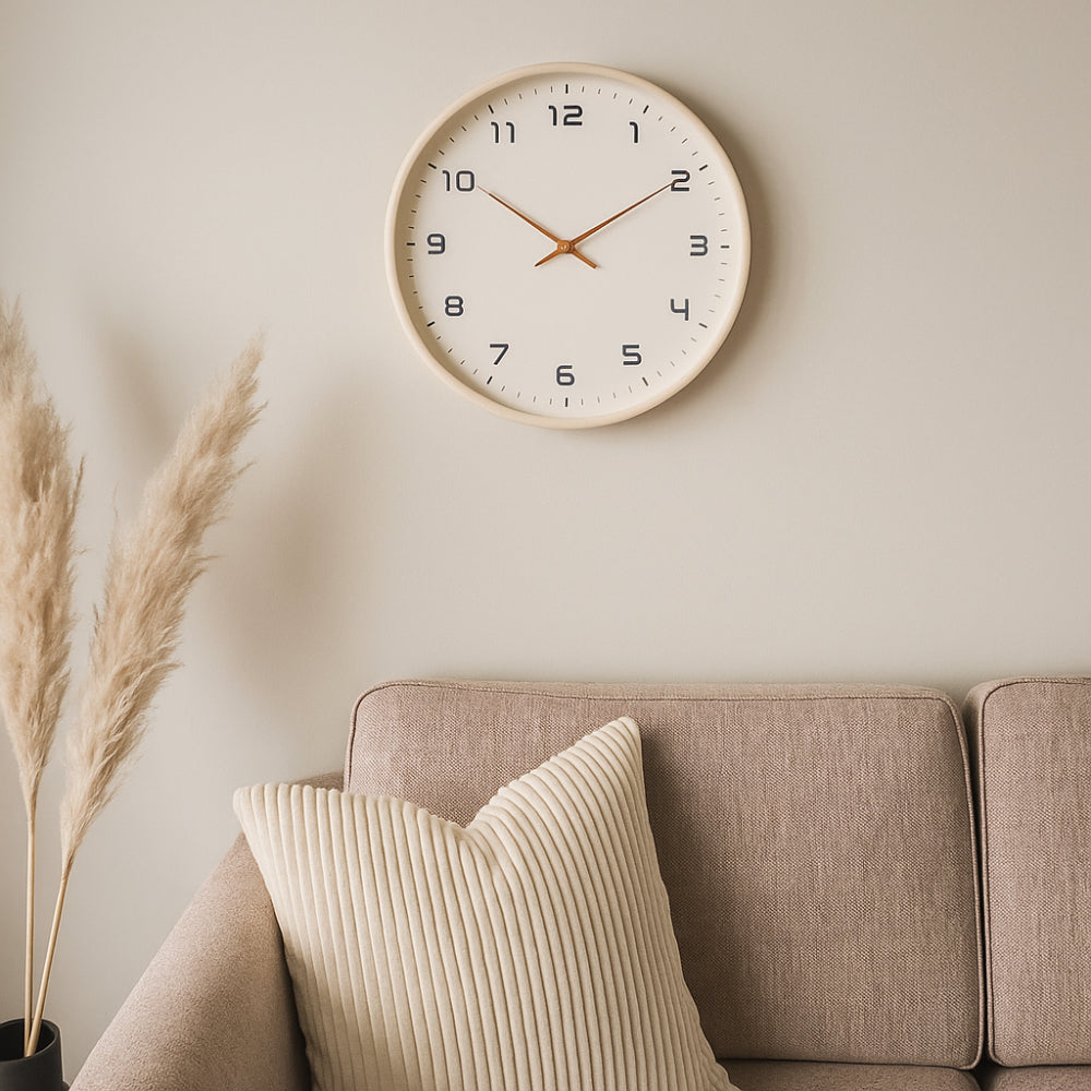Small cream-rim wall clock with white face, black numerals, and gold hands