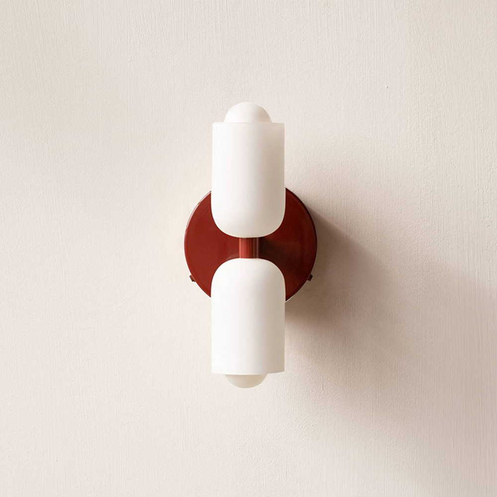 Red wall sconce lamp with two frosted cylindrical acrylic shades and curved metal backplate