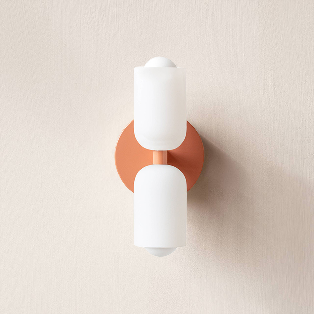 Orange wall sconce lamp with two frosted cylindrical acrylic shades and circular backplate