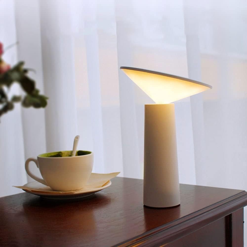 White table lamp with slim cylinder base and glowing angled shade