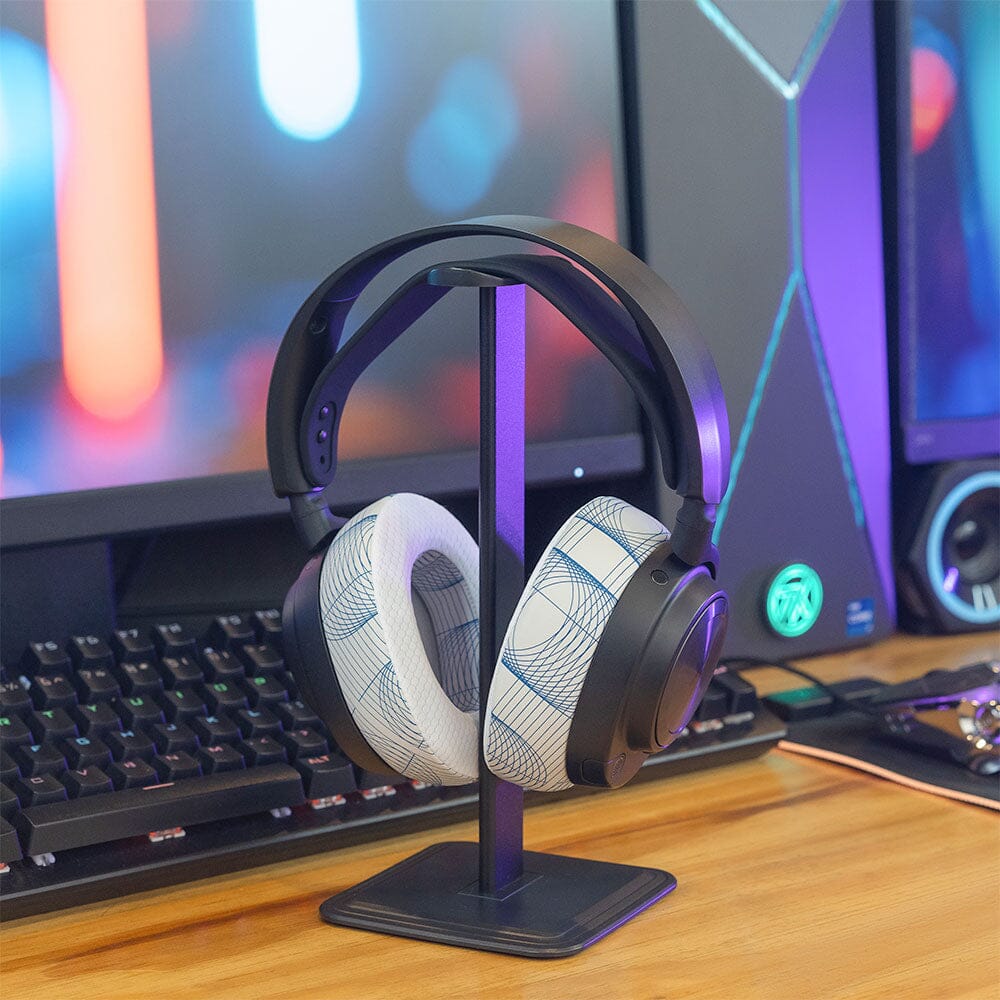Headphones on stand wearing white cooling gel earpads with blue patterned panels