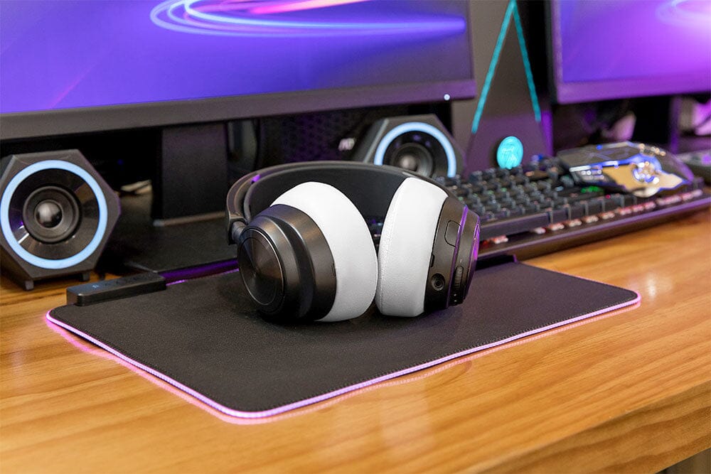 Over-ear headphones with white replacement earpads on a desk setup