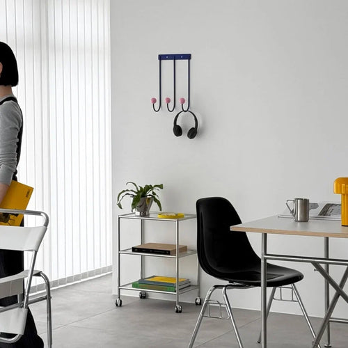 Blue and pink color block wall hooks with three curved metal hooks and headphone-style hooks