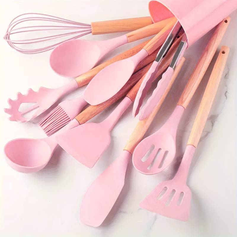 Pink silicone kitchen utensil set with light wood handles: spatulas, ladle, whisk