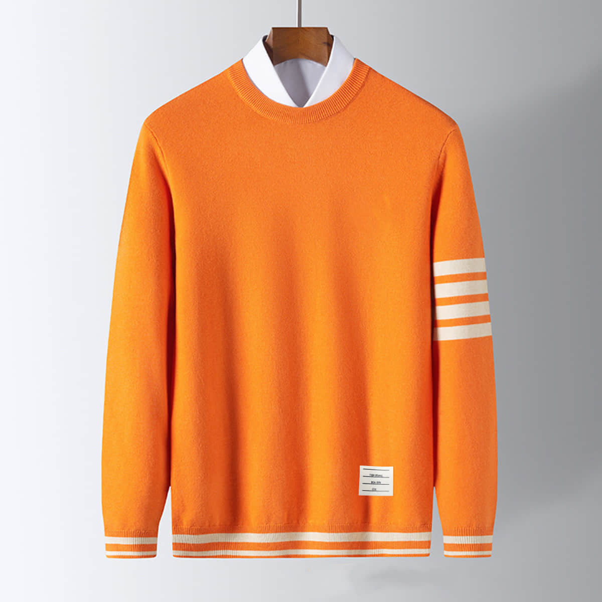 Men's pullover sweater, orange knit with white striped sleeve cuffs and hem band.