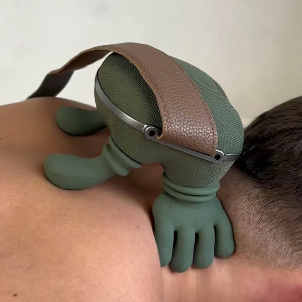 Close-up of green neck massager with brown strap and fingered vibration pads