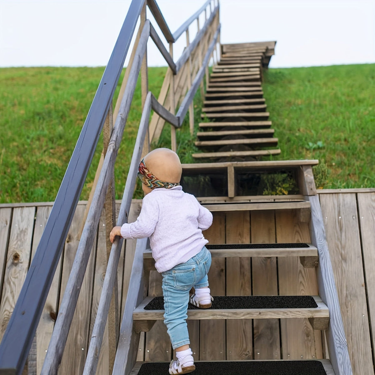 Child walking up outdoor stairs with black anti-slip tread strips on each step