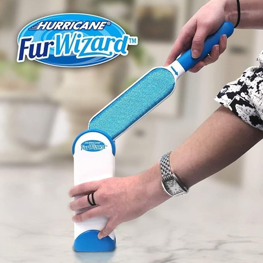 Reusable pet hair lint brush held in hand, blue pad on white base