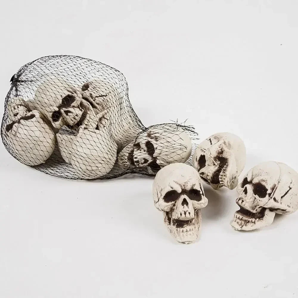 Set of mini white skeleton skull decorations in a mesh bag, skull figurines visible