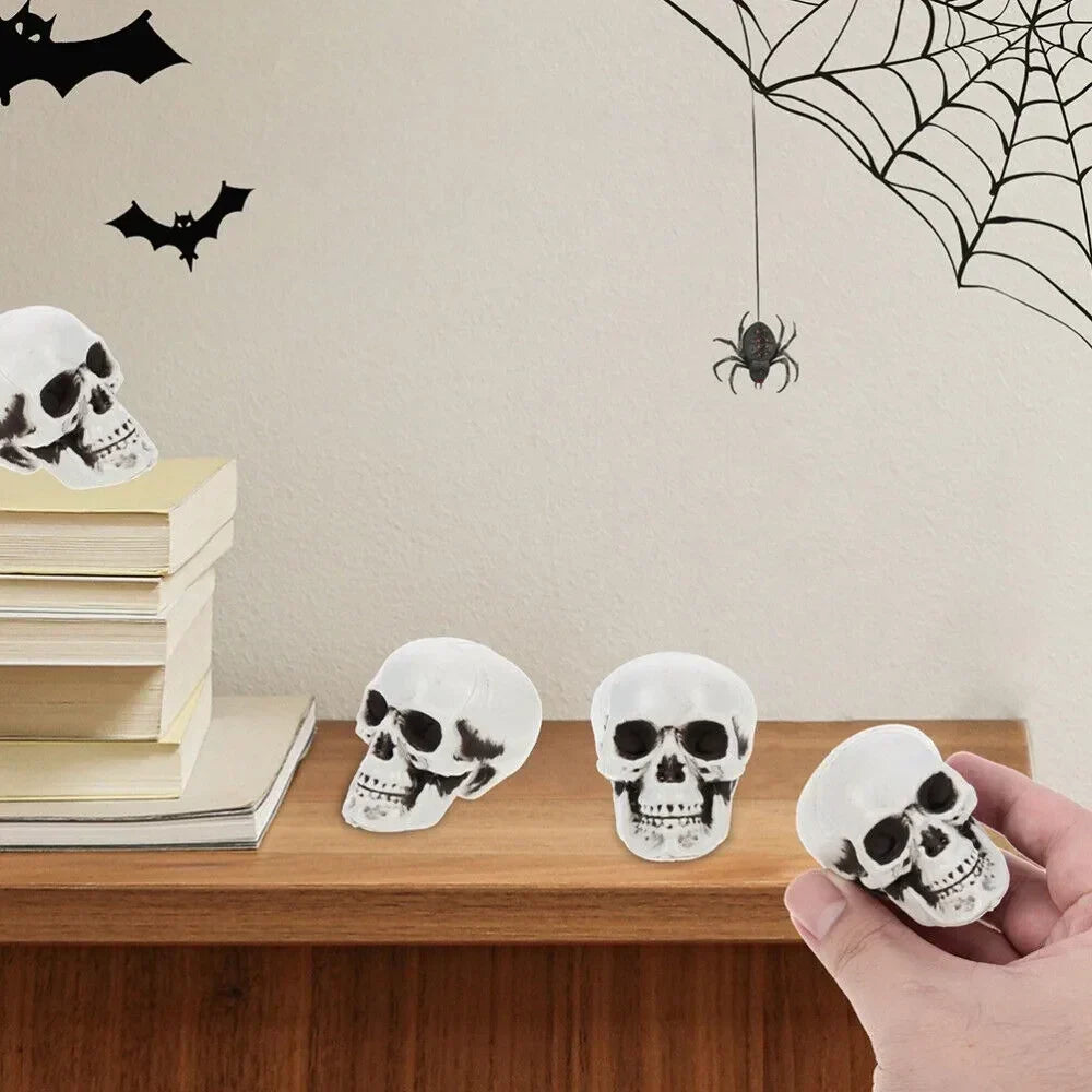 Mini white skeleton skull figurine decorations, three small skulls on a table