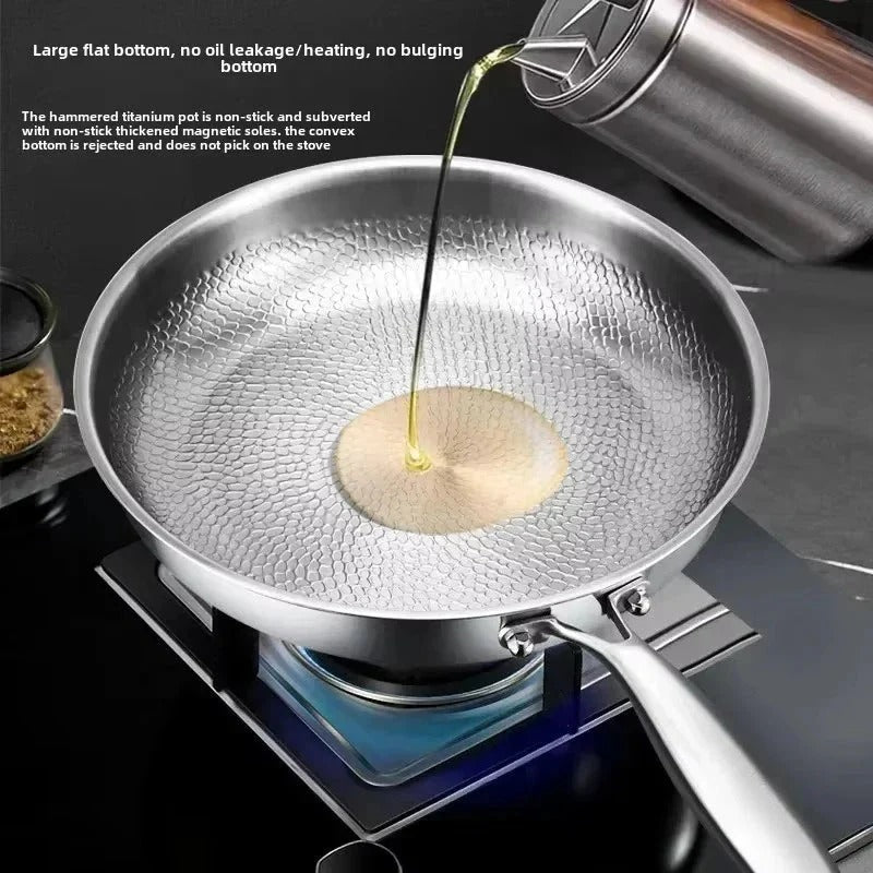 Hammered titanium frying pan with oil being poured into textured center