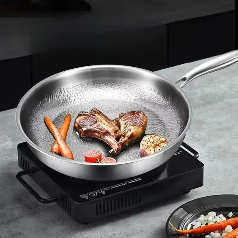 Stainless steel frying pan with food on a gray countertop