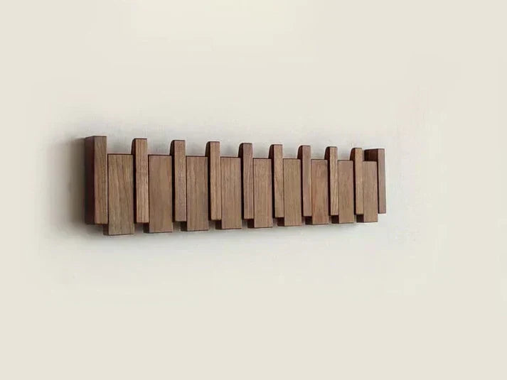 Dark wooden fold-out wall hook rack with multiple hinged hooks