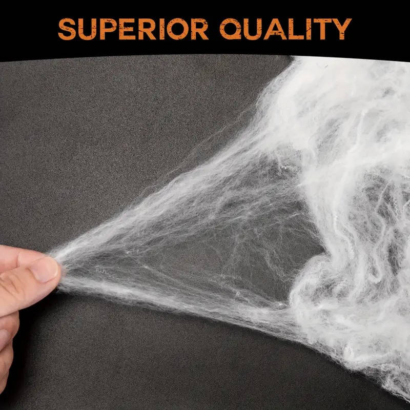 Stretchable white spider web material being pulled apart for a spread-out look