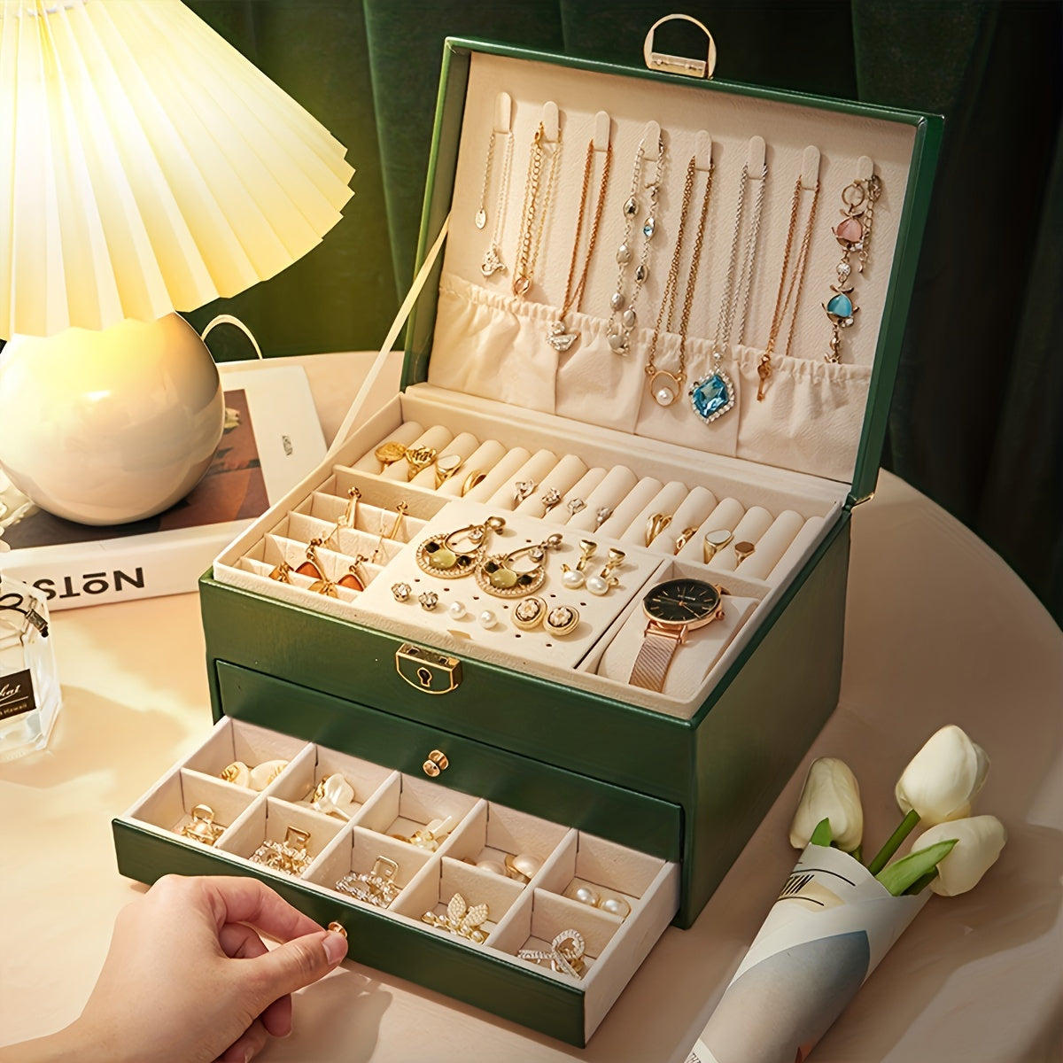 Green multi-layer jewelry storage box with open lid showing necklace and earring slots.
