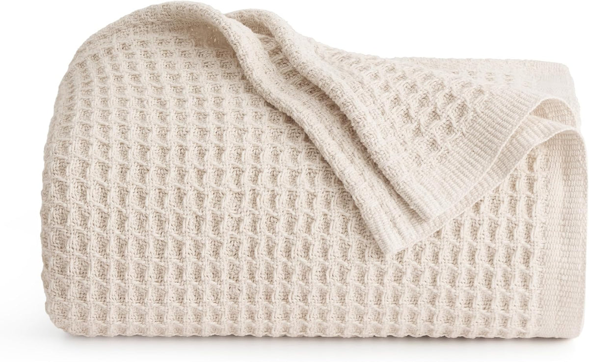 Cotton waffle-weave cooling blanket, rolled light beige with waffle grid texture